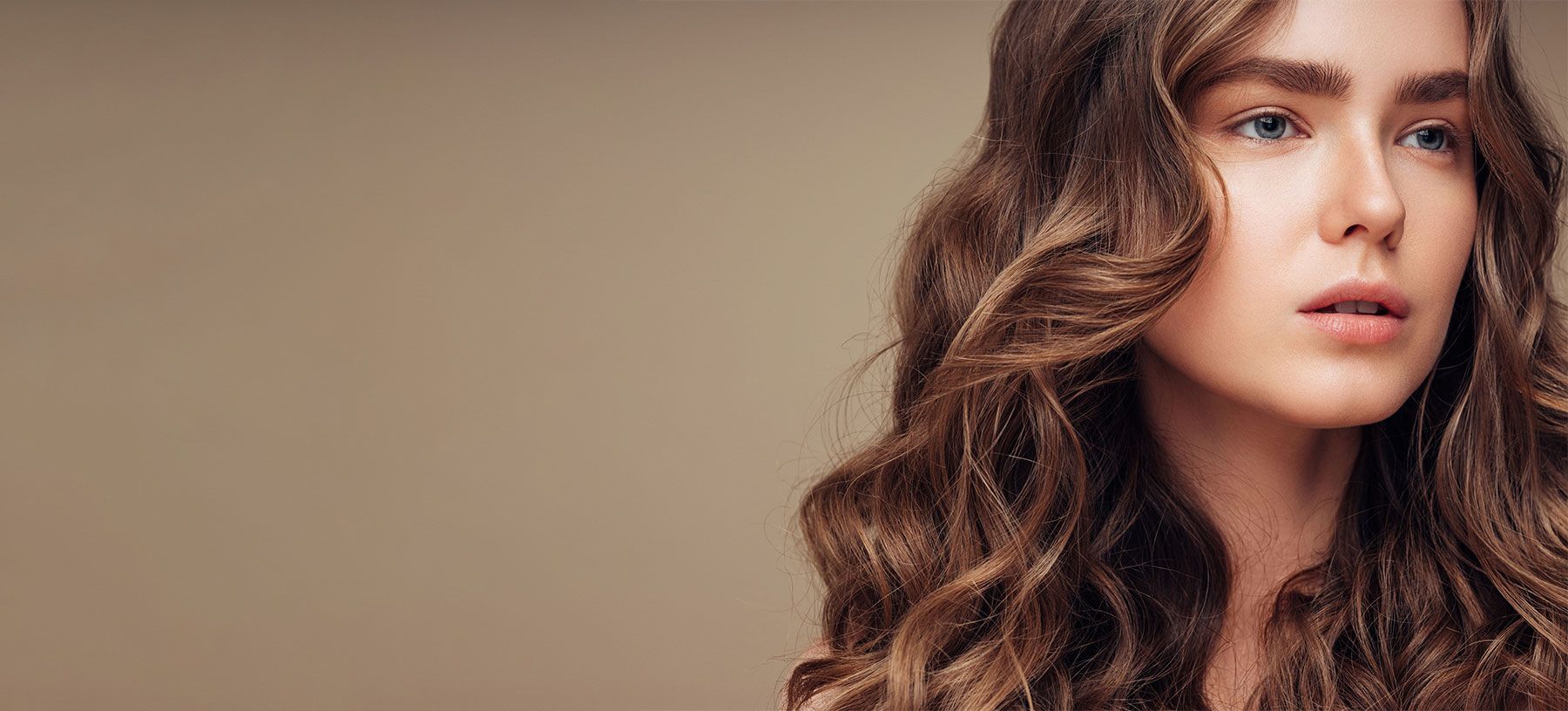 Fishers Botox model with wavy hair against neutral background.